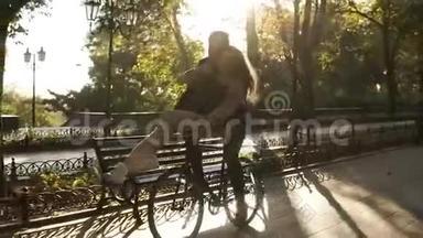 有<strong>爱心</strong>的年轻夫妇在户外活动中骑在同一辆自行<strong>车</strong>上玩得很开心，背景是阳光背光。 女孩是